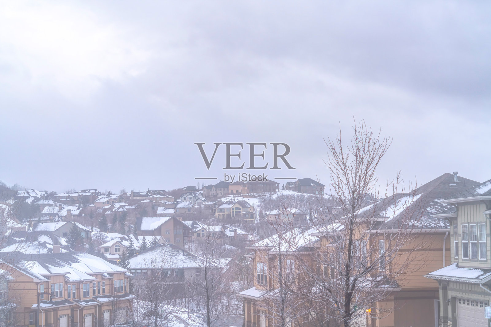 在多云的天空下，一个多层房屋的社区里有雾的冬天照片摄影图片