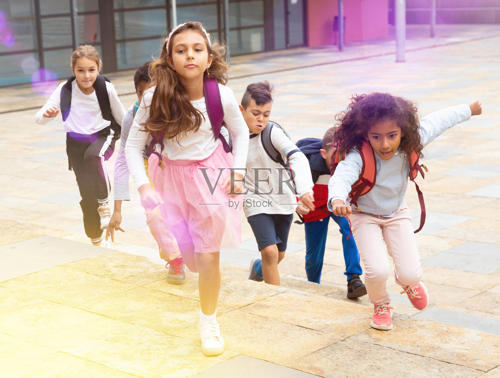 一组阳性学童在街上跑步照片摄影图片