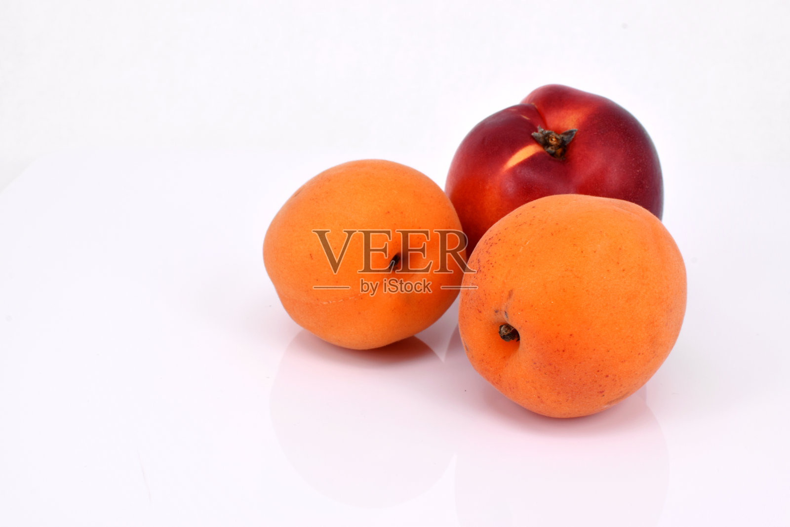 两个杏和一个油桃的特写。照片摄影图片