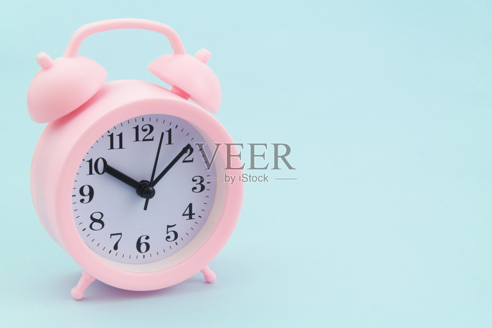 蓝色背景上的粉色闹钟照片摄影图片