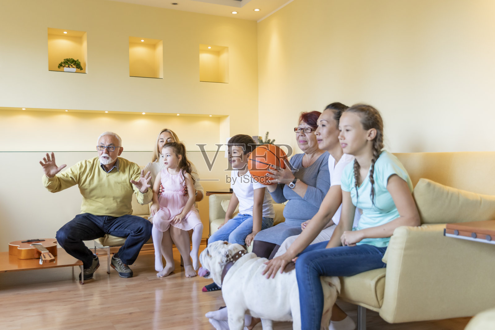 一个幸福的家庭在家里看篮球比赛。照片摄影图片