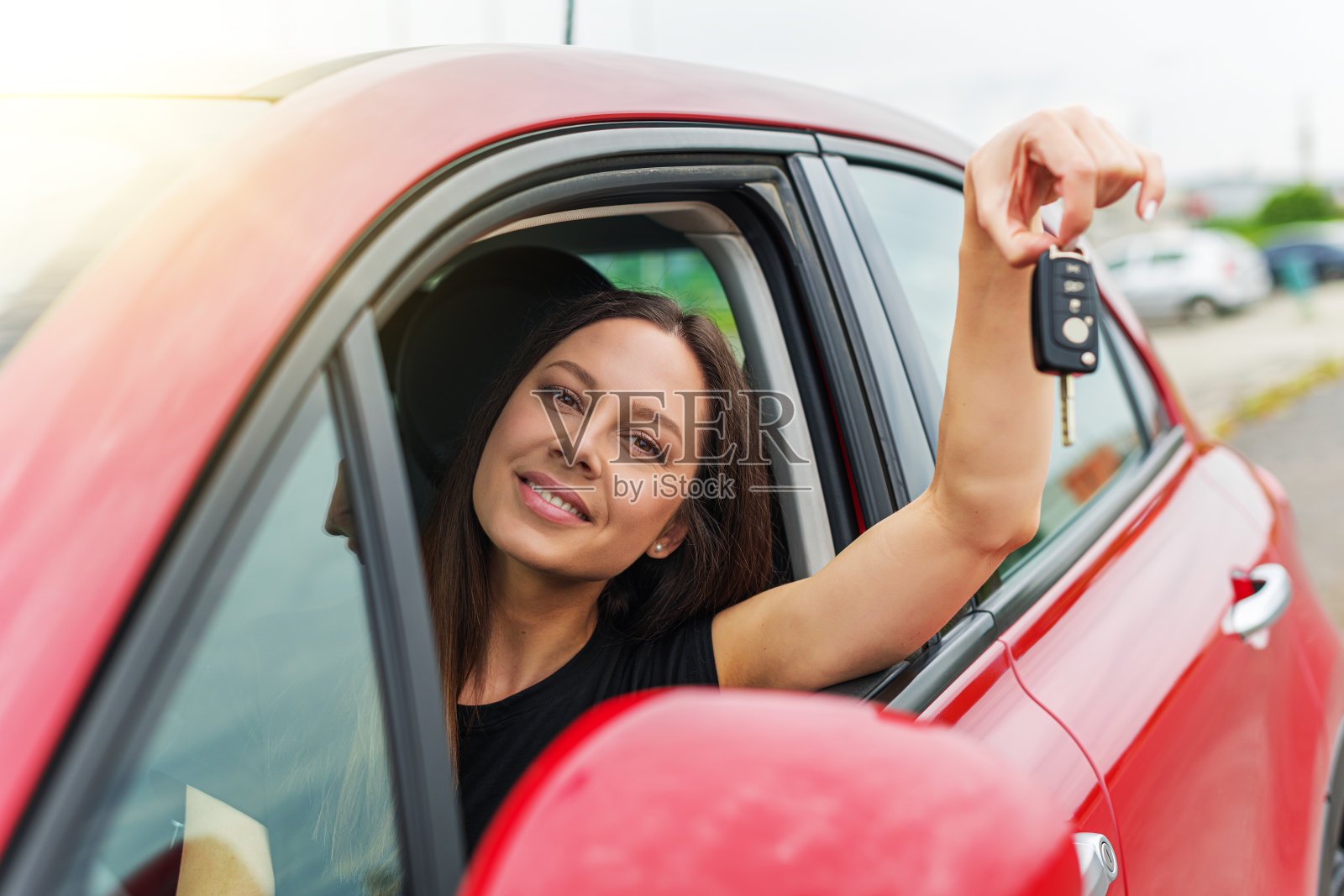 迷人的年轻女子展示了车钥匙。照片摄影图片