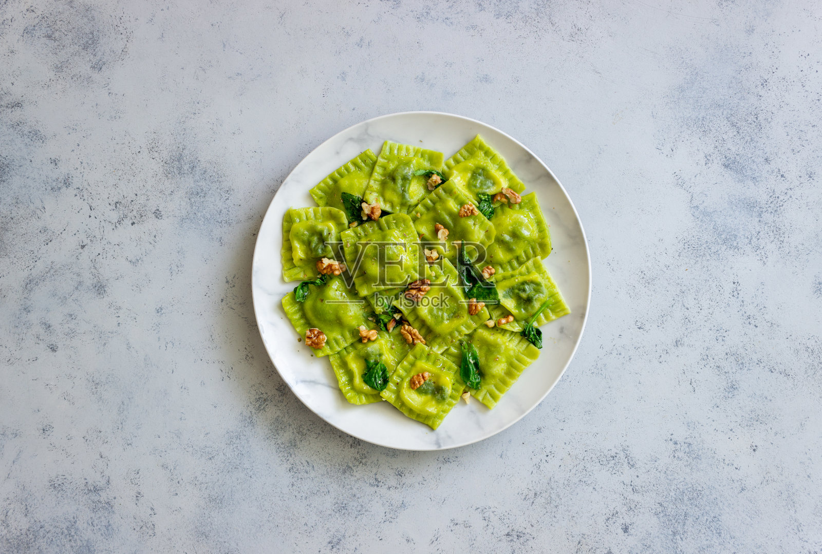 意大利乳清干酪、菠菜和坚果的绿色馄饨。健康饮食。素食。意大利菜。照片摄影图片