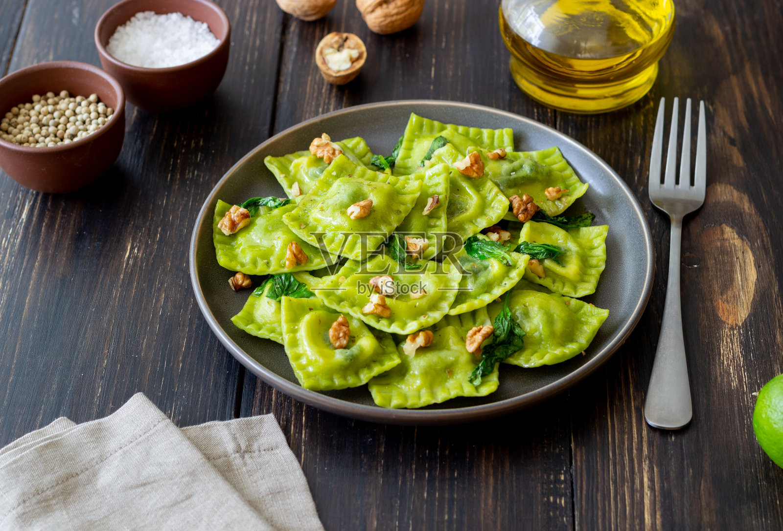 意大利乳清干酪、菠菜和坚果的绿色馄饨。健康饮食。素食。意大利菜。照片摄影图片