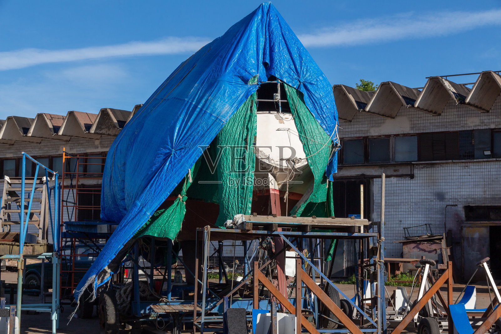 游艇在干船坞修理时用遮阳篷遮着照片摄影图片