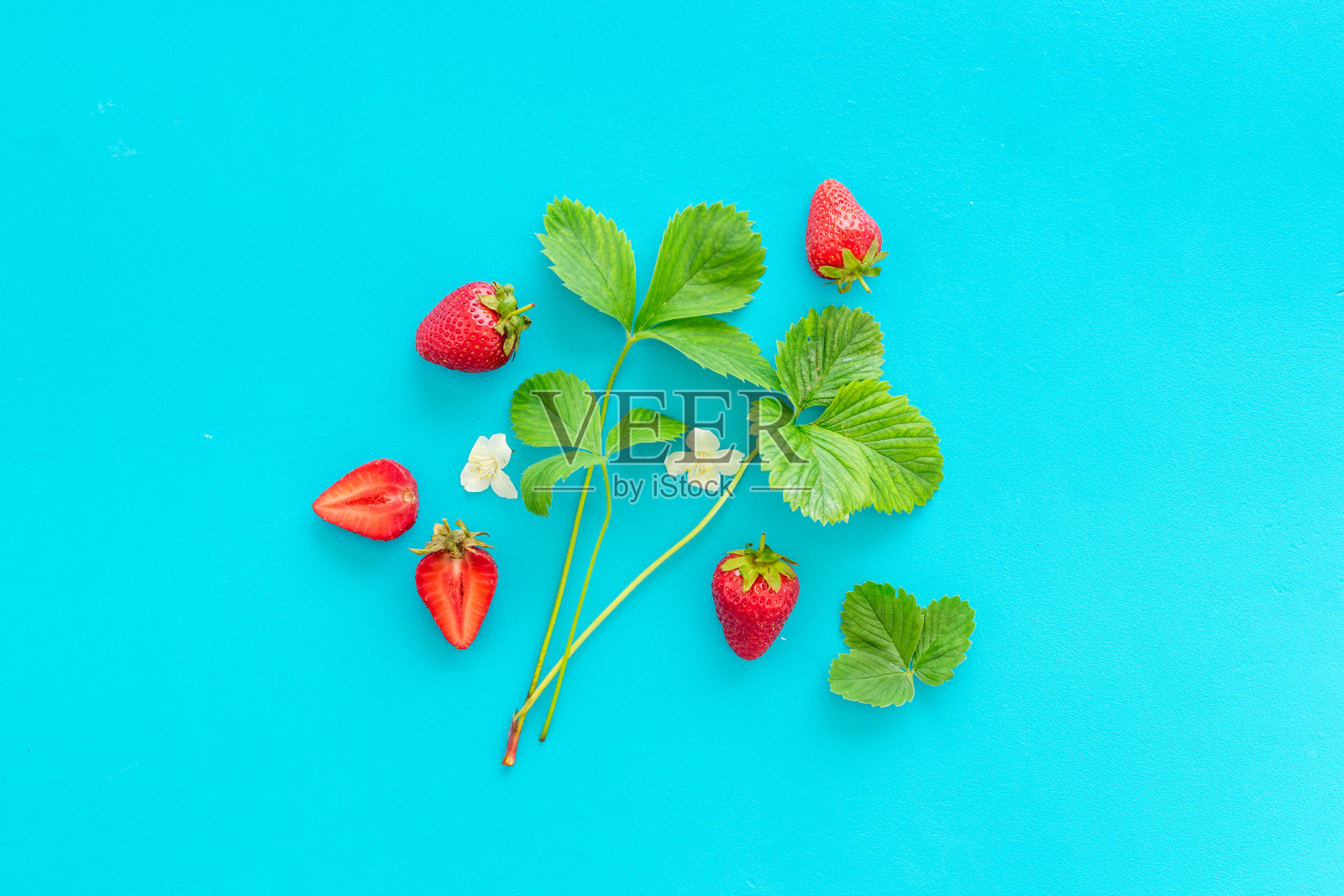 布局成熟的草莓与绿色的叶子照片摄影图片