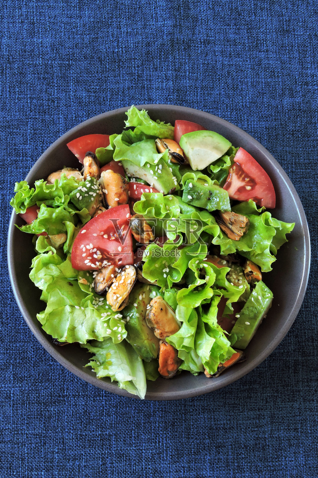 新鲜的牛油果和贻贝沙拉。照片摄影图片