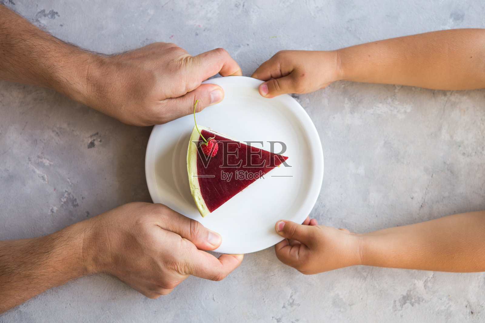 我的蛋糕。男人的手和孩子的手拿出一块蛋糕。覆盆子蛋糕. .婚礼甜点。蛋糕的生日聚会。美味的甜点。照片摄影图片