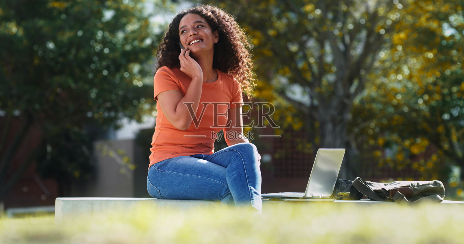 一张年轻女商人在外面用智能手机打电话的照片照片摄影图片