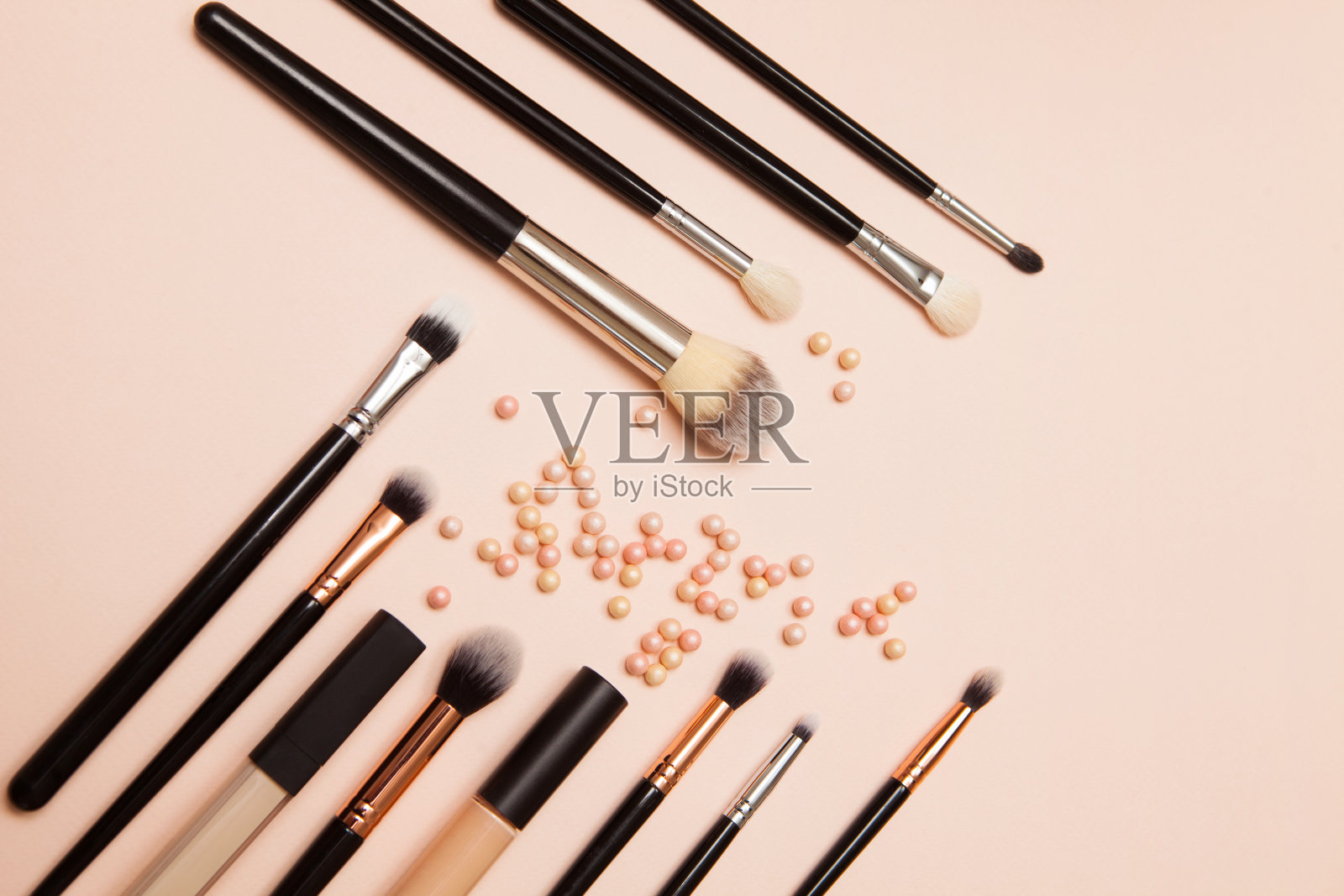 各种化妆刷在粉红色的背景。化妆刷用于护理皮肤。照片摄影图片