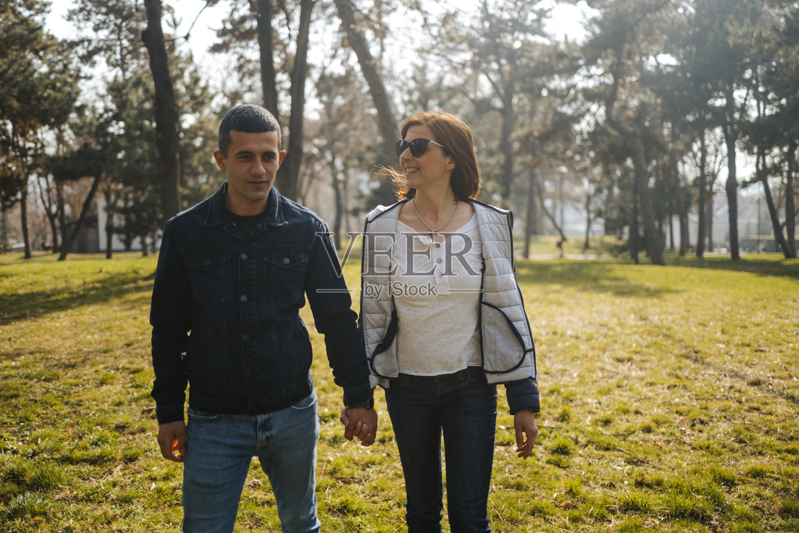 年轻的情侣在城市公园散步，一起享受美丽的大自然照片摄影图片