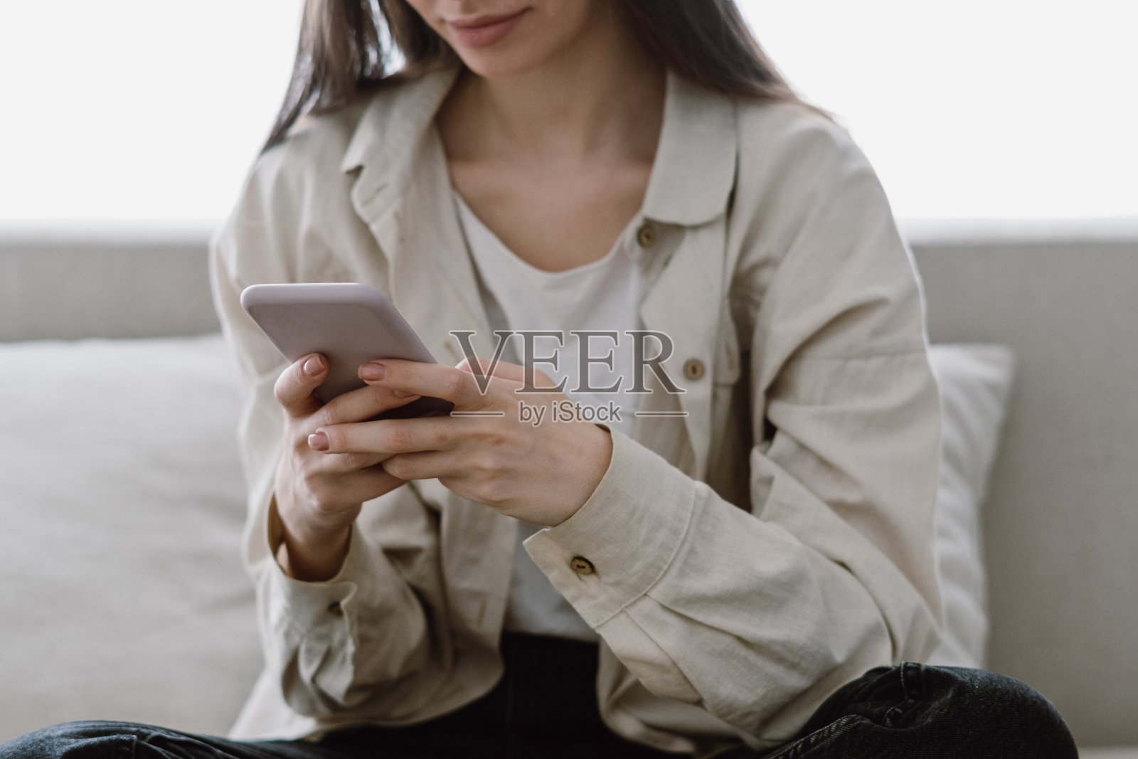 一名年轻女子在看智能手机上的信息照片摄影图片