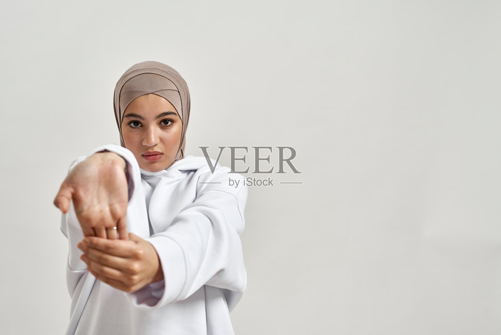 美丽的年轻阿拉伯女孩在希贾布显示打开的手掌照片摄影图片