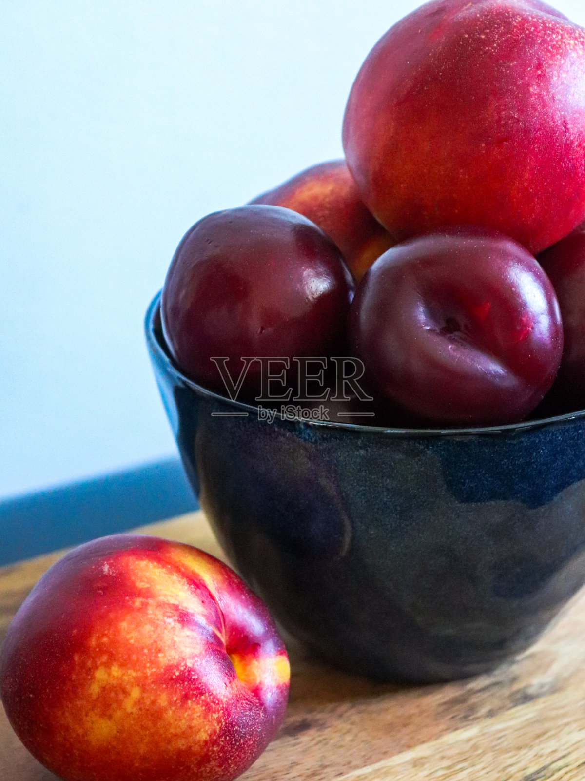 桌子上的碗里有油桃和李子照片摄影图片