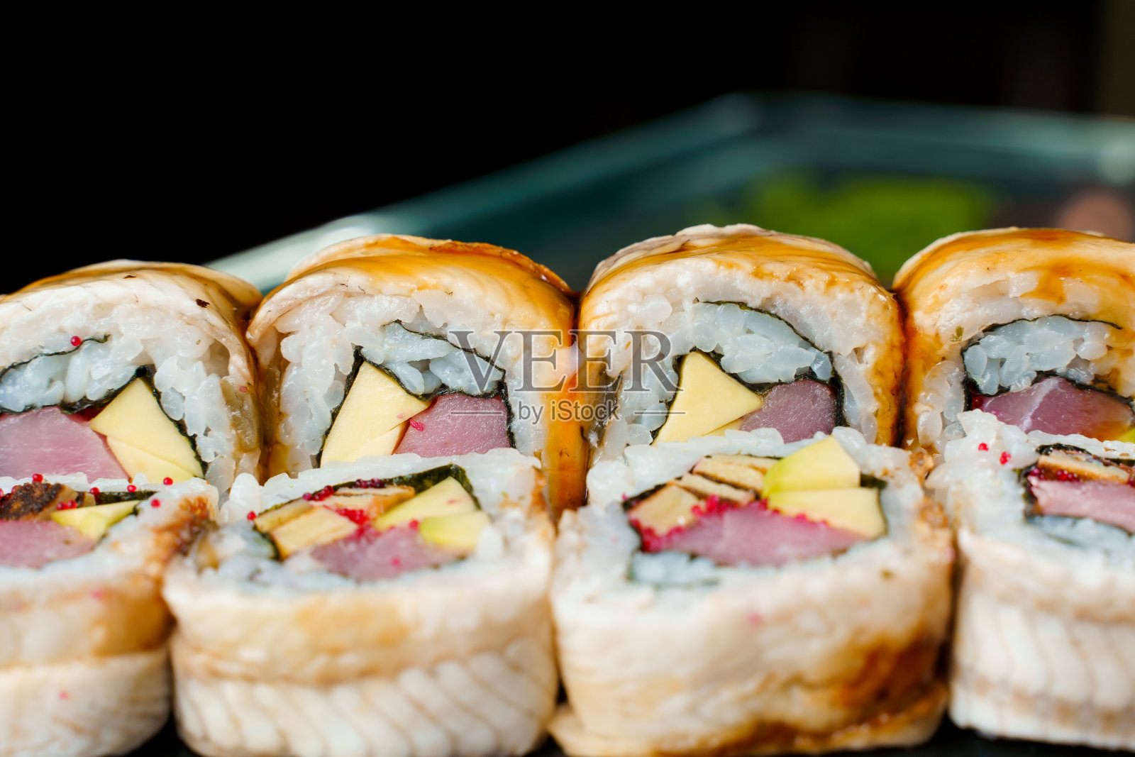 Unagi卷与金枪鱼，tobiko鱼子酱，切达奶酪，紫菜，Unagi酱特写。日本传统食物。照片摄影图片