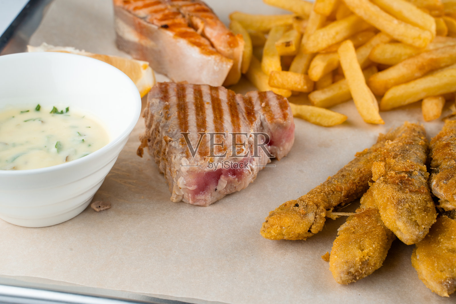 烧烤海鲜串，木串上烤贻贝，金枪鱼，三文鱼，白汁和柠檬照片摄影图片