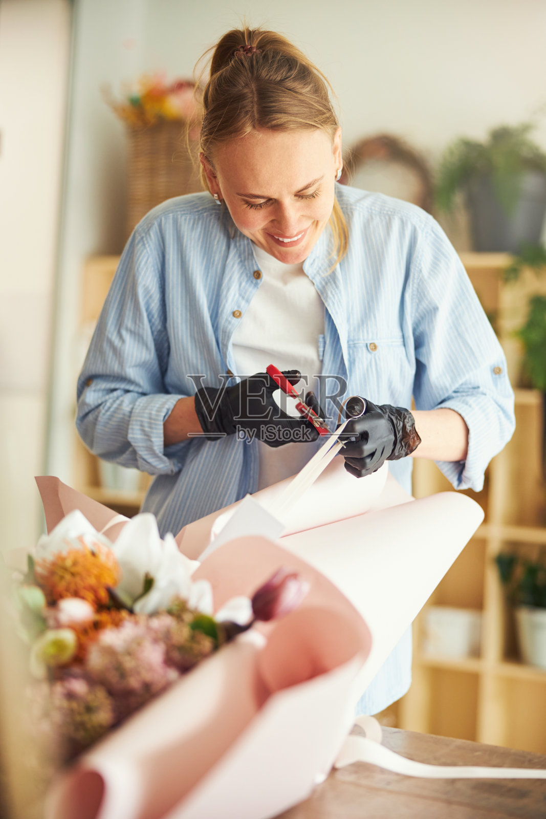 欢乐的花店在丁腈手套结束一个插花照片摄影图片