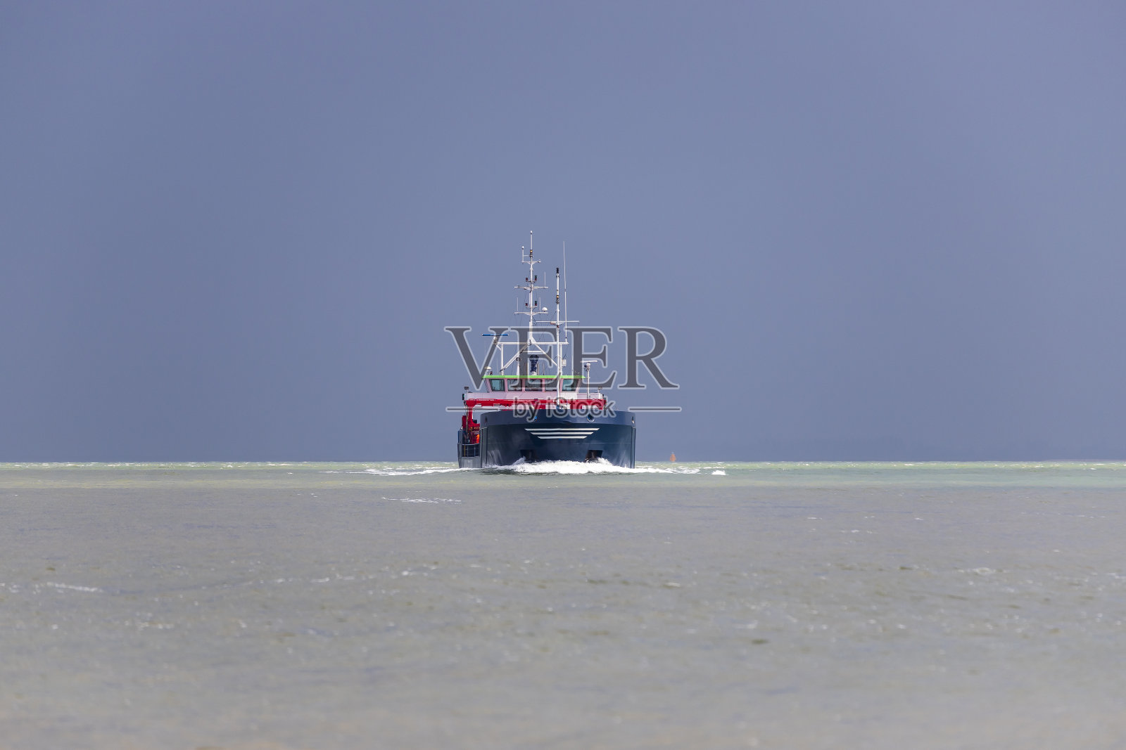 在海上航行的大船。背景是没有云彩的蓝天照片摄影图片