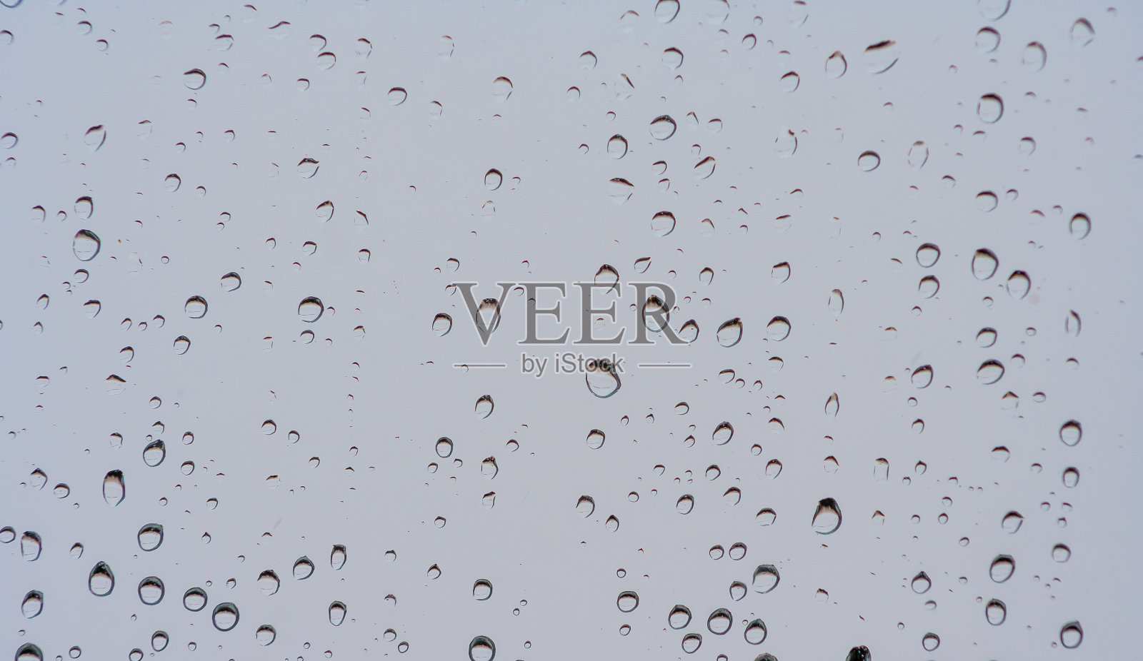 雨滴落在窗户或玻璃上。灰色湿玻璃花纹纹理。摘要照片摄影图片