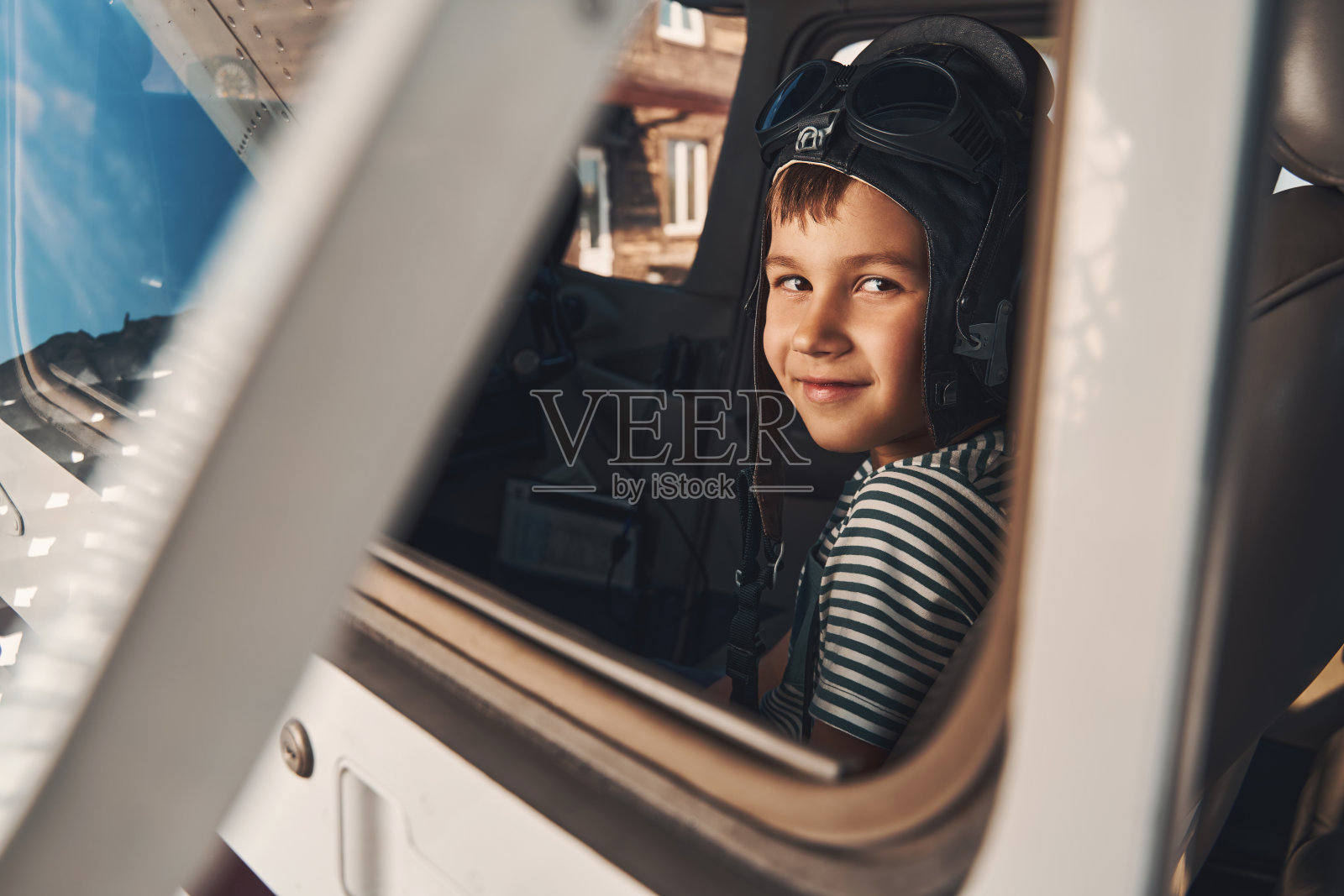 可爱的男孩坐在飞机驾驶舱里照片摄影图片