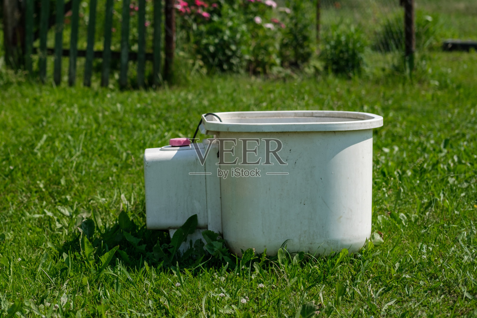 草地上放着一台旧洗衣机。照片摄影图片