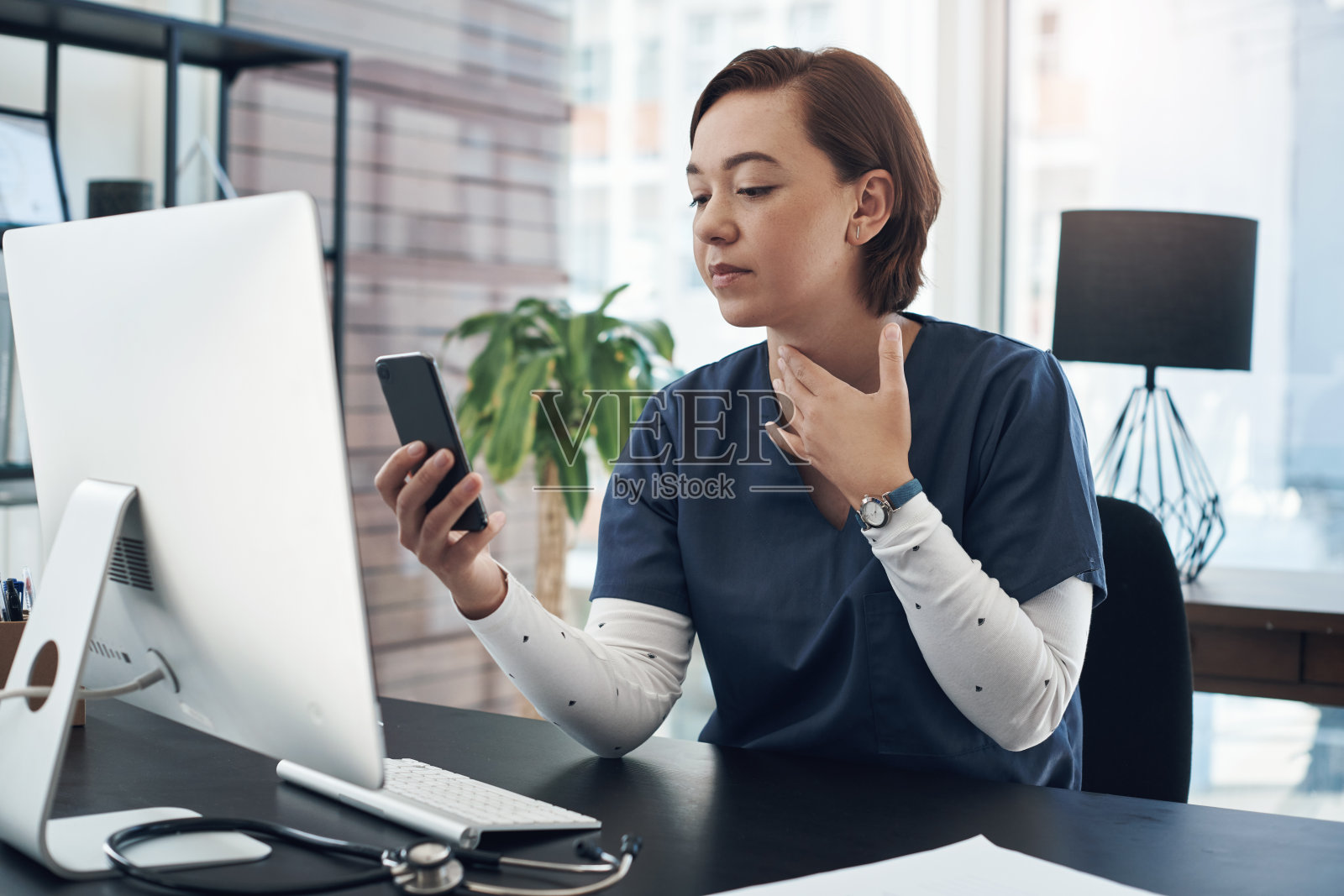 一张年轻医生在办公室用手机的照片照片摄影图片