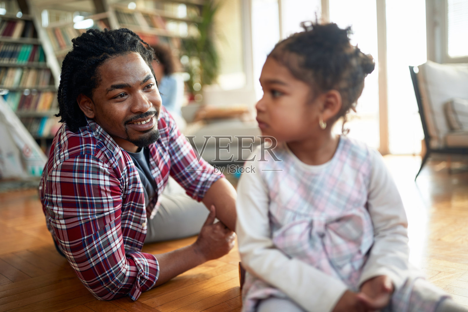 一个年轻的父亲在家里和女儿玩的时候充满了情感。家人，在一起，爱，玩耍的时间照片摄影图片