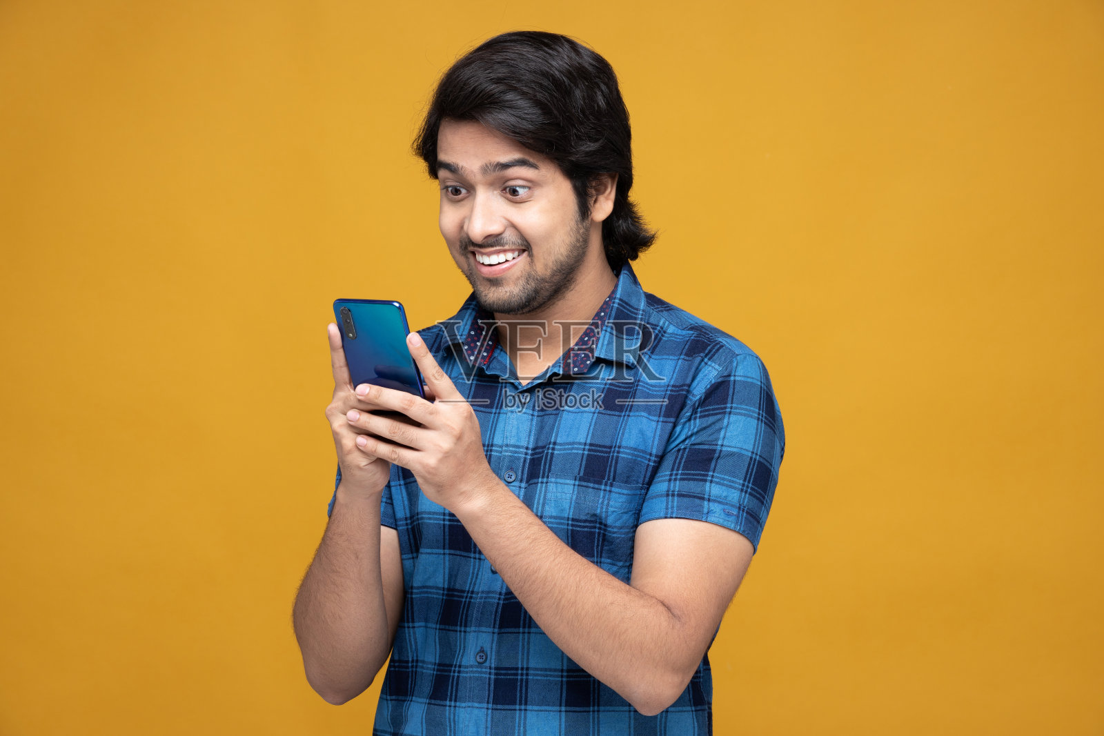 年轻男子使用手机孤立在黄色背景:-股票照片照片摄影图片