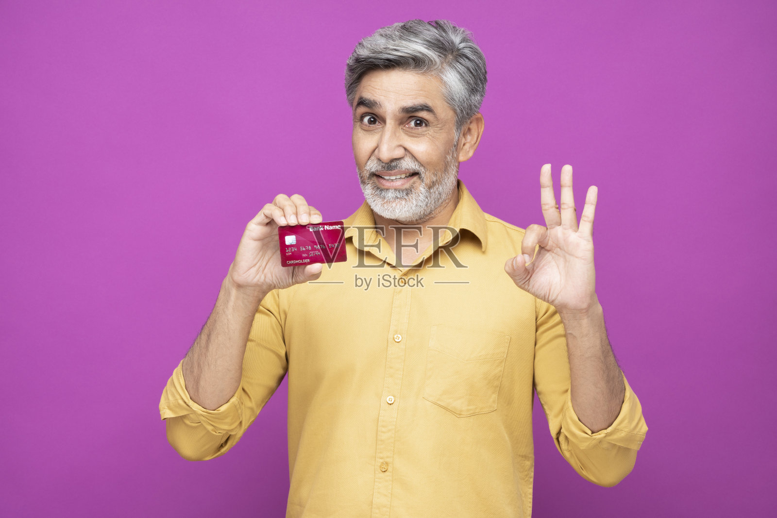 肖像英俊的成熟男子站在孤立的粉红色背景:股票照片照片摄影图片