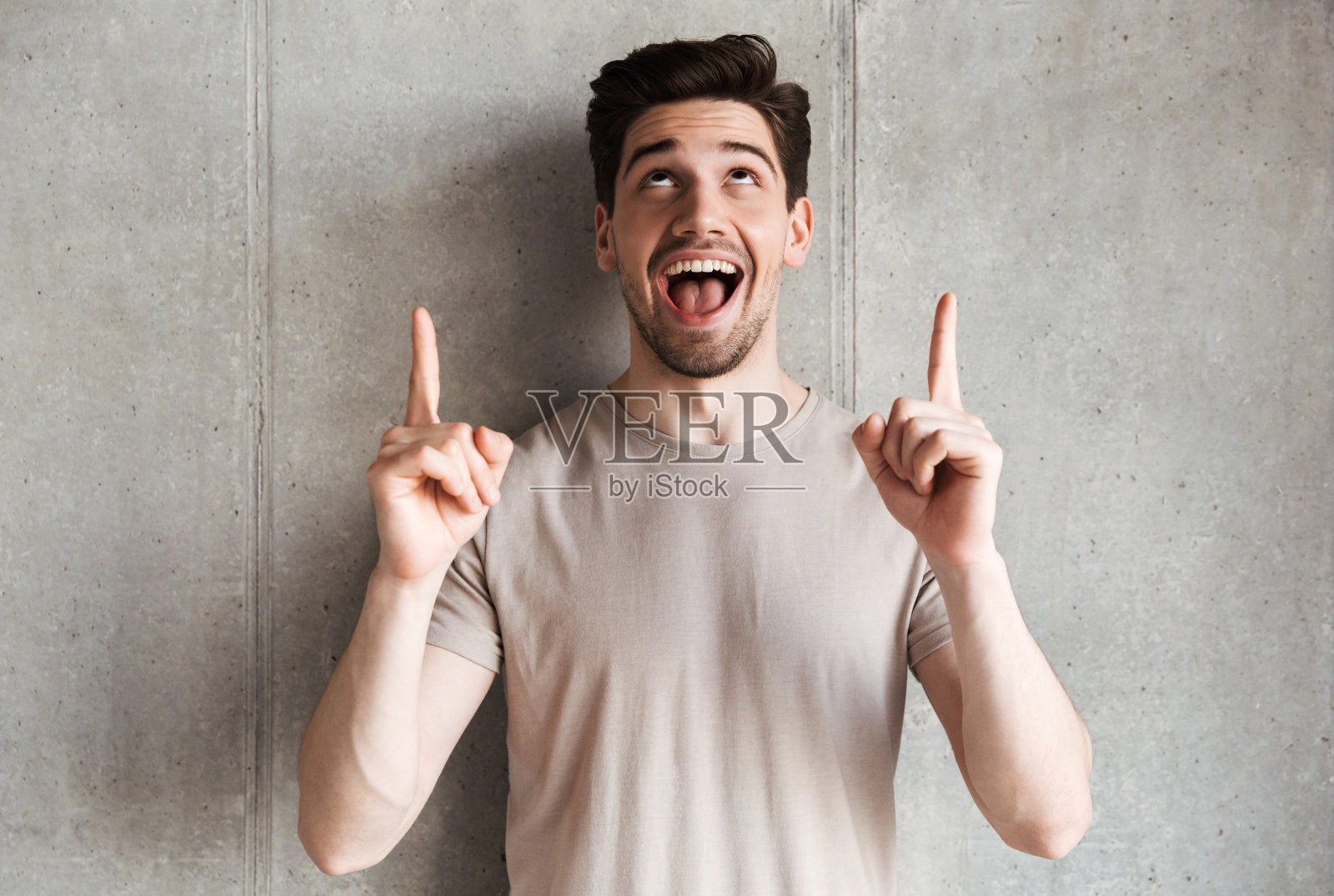 兴奋的微笑的年轻人指着文案。照片摄影图片