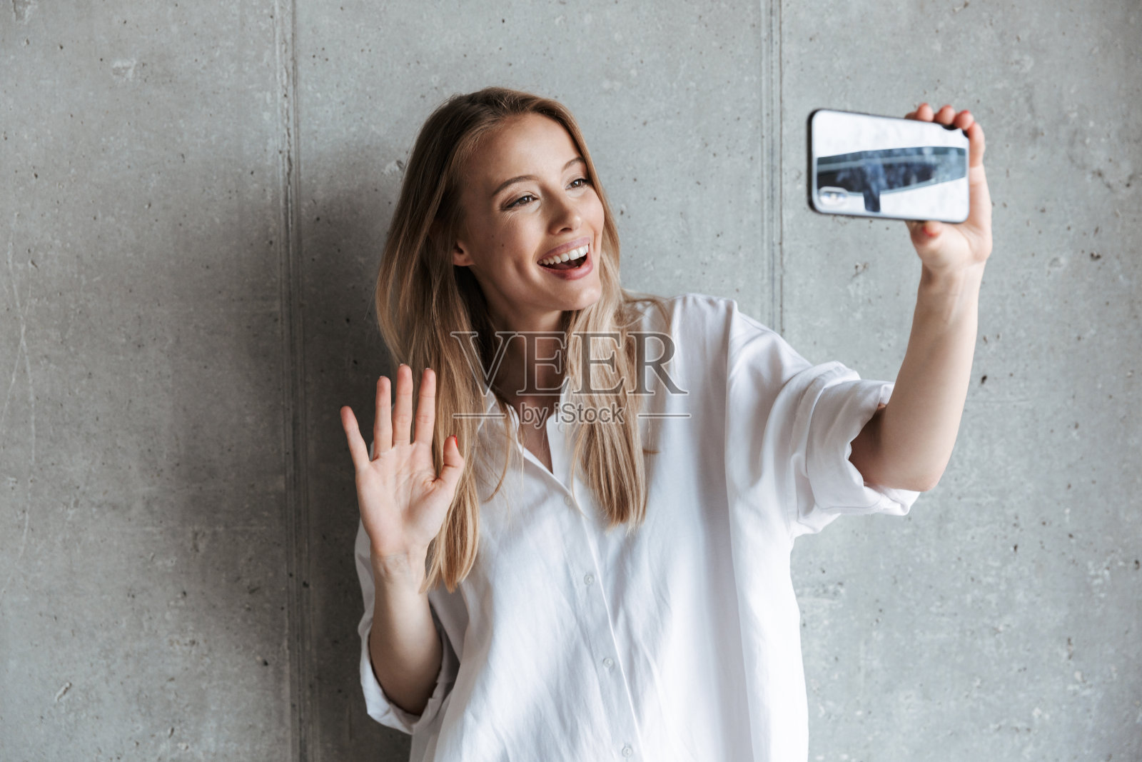 一个快乐的女孩在自拍并挥手照片摄影图片