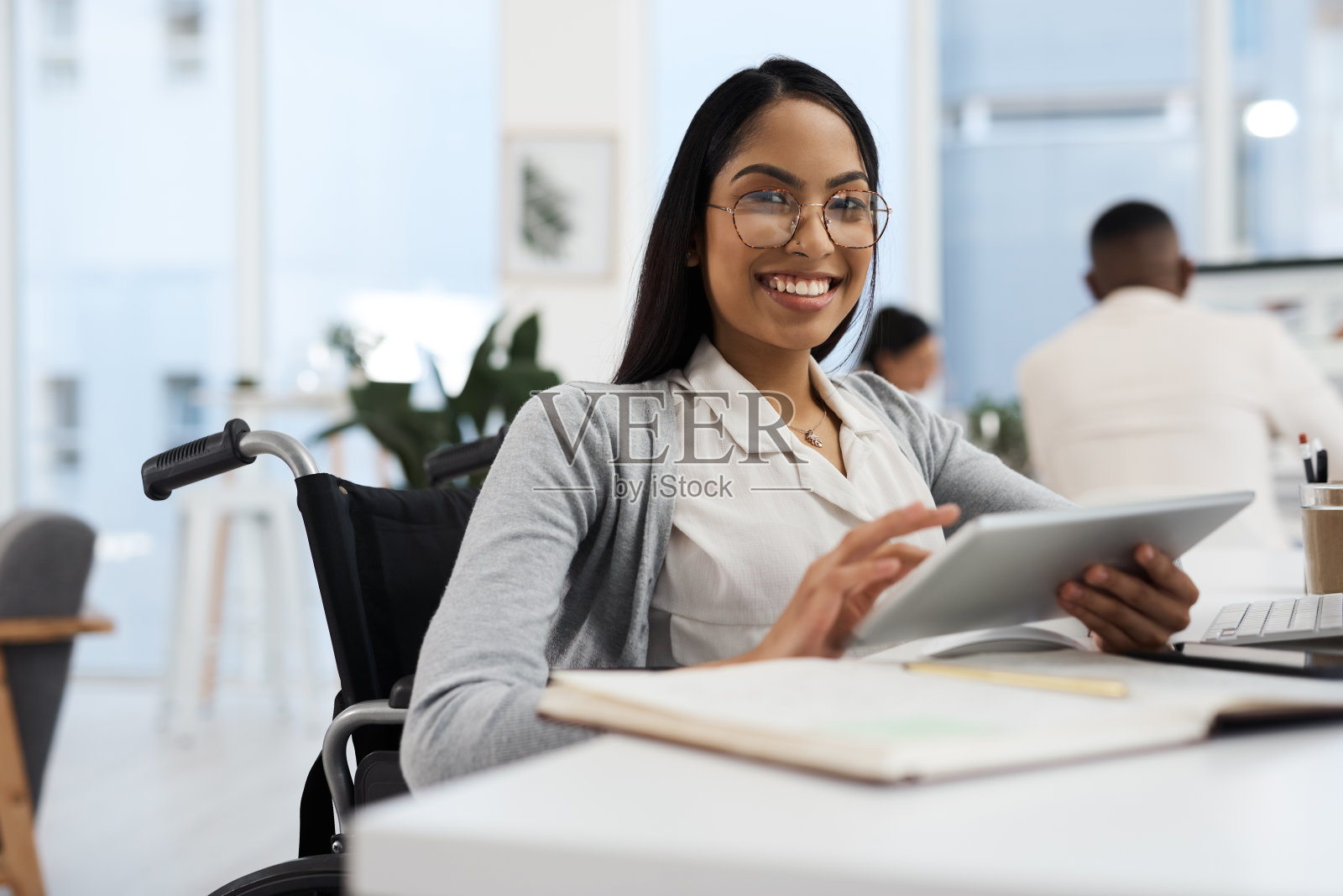 一位迷人的年轻女商人在办公室办公桌前用平板电脑工作的裁剪肖像照片摄影图片