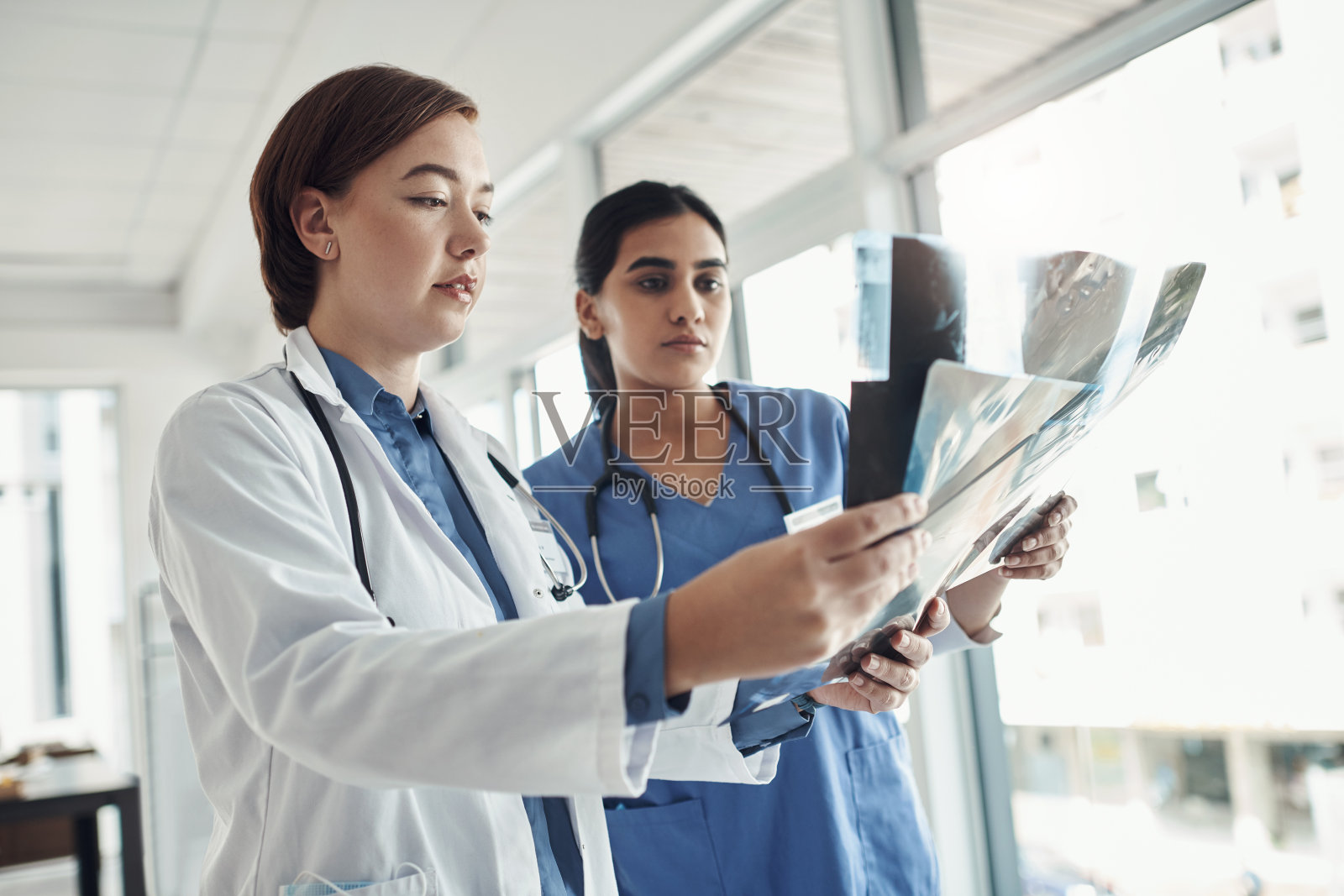 两位年轻医生在医院检查X光片的照片照片摄影图片