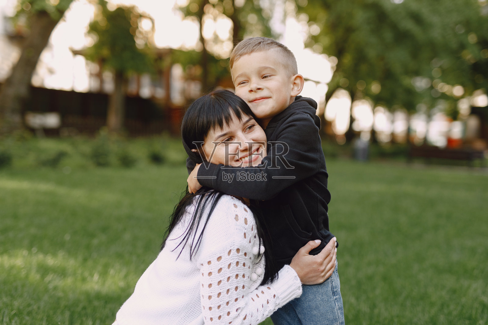 母亲和儿子在夏天的公园里玩照片摄影图片