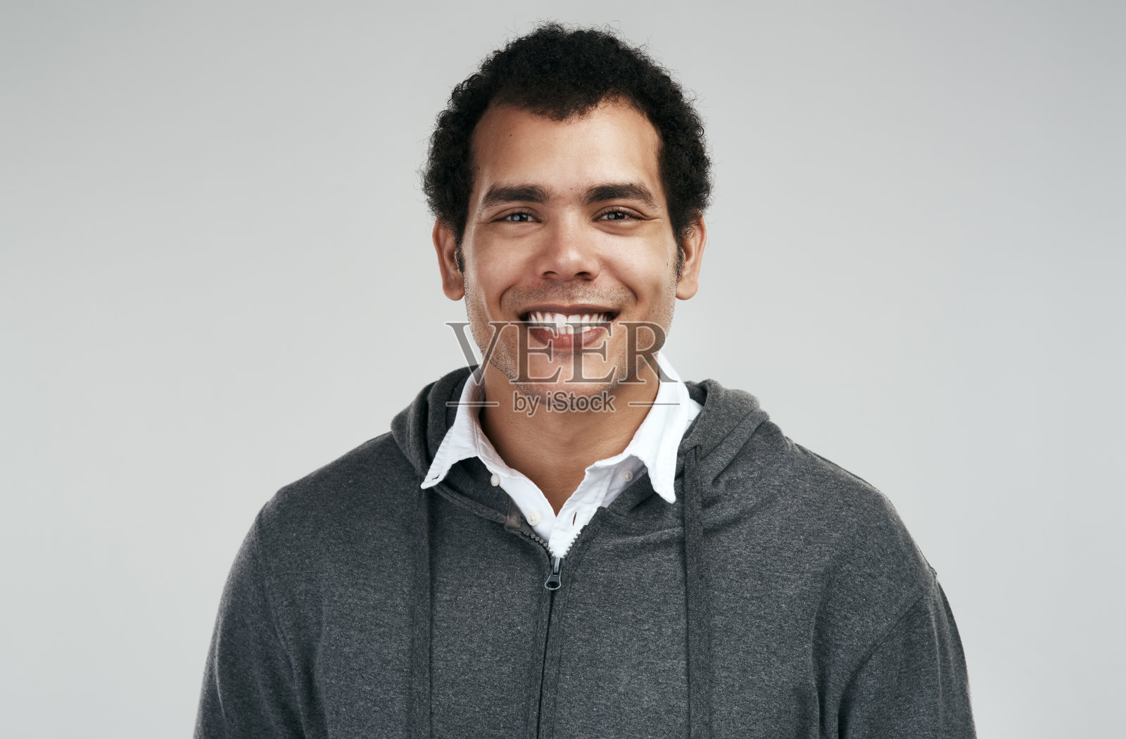 一个英俊的年轻人站在一个灰色的背景照片摄影图片