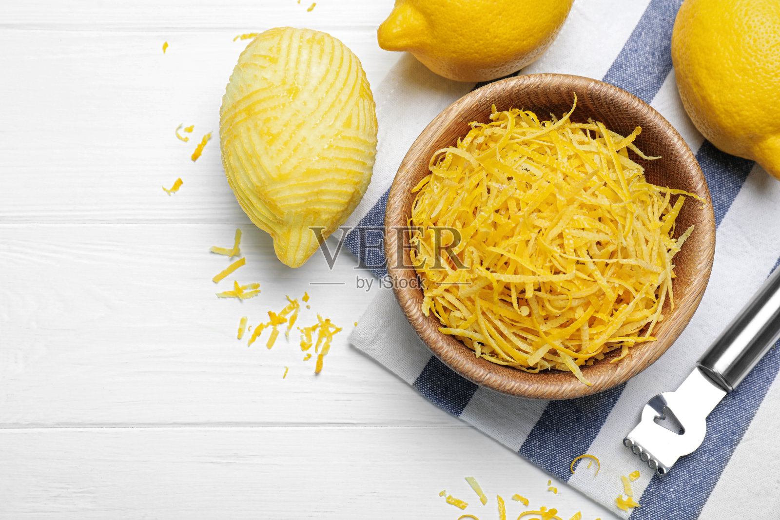 在白色木桌上放置新鲜柠檬皮。空间的文本照片摄影图片