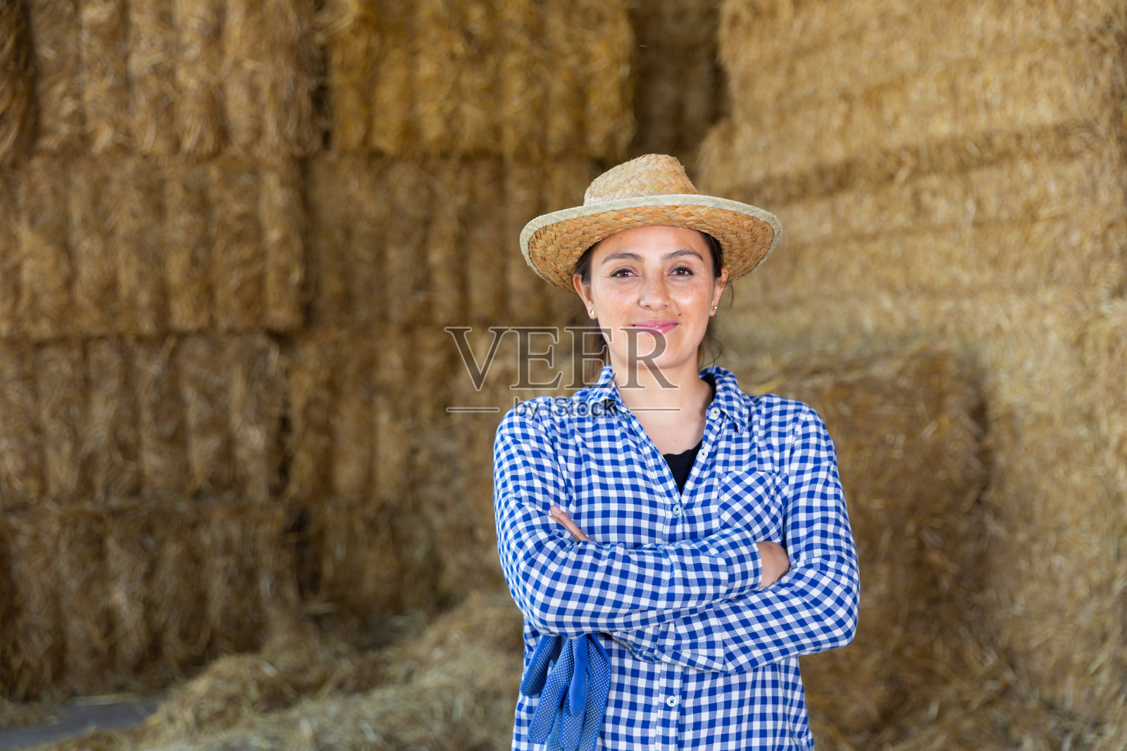 成功的年轻女农民在秸秆堆旁摆姿势照片摄影图片