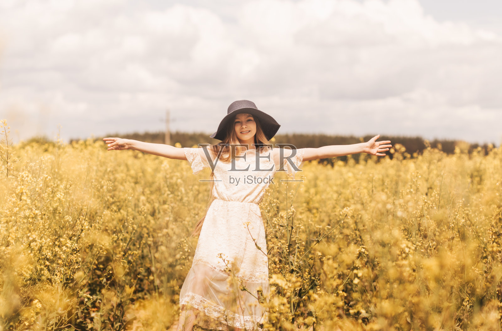 一个快乐的小女孩在油菜花盛开的田地里享受大自然。对青春和自由的向往照片摄影图片