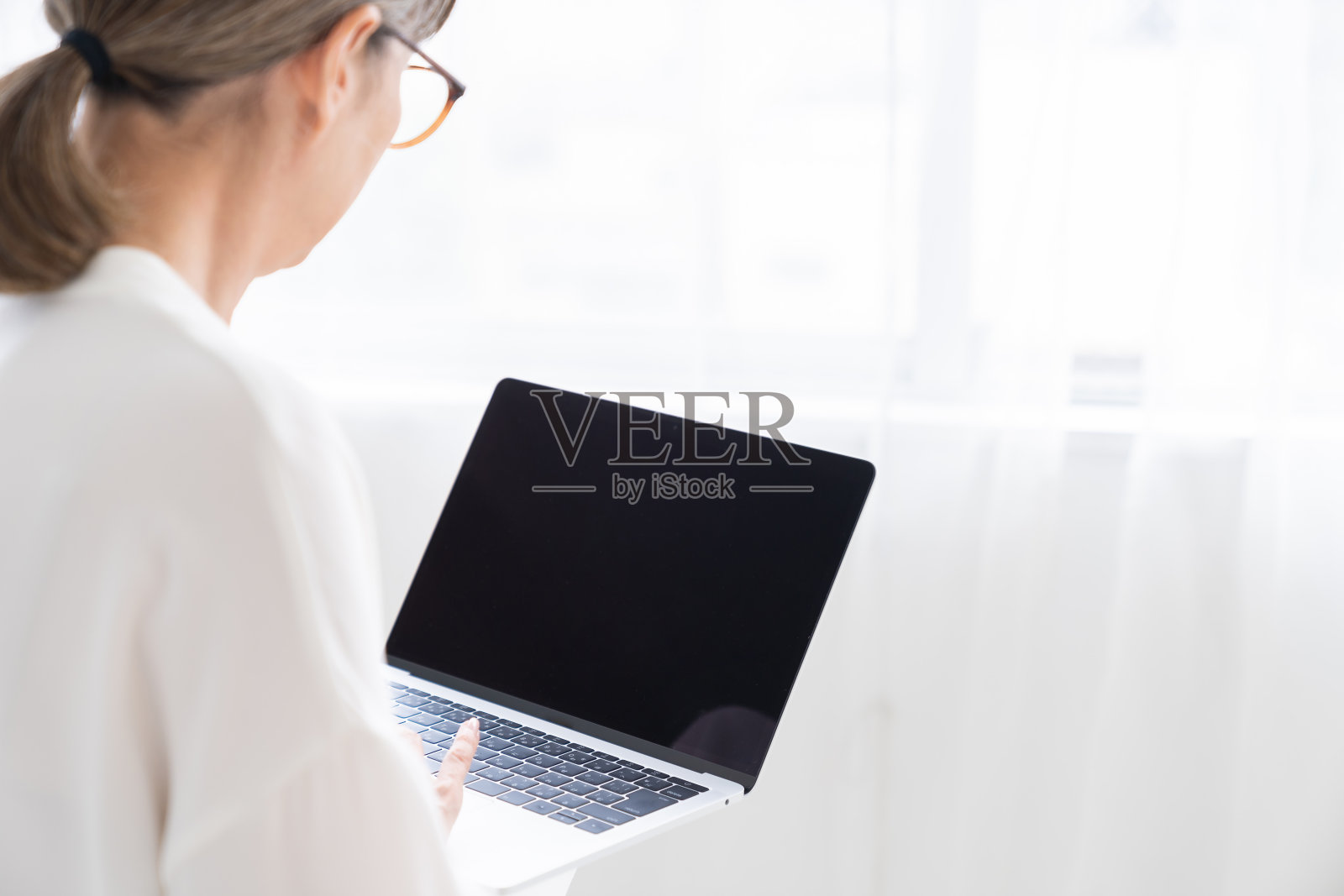 老年妇女使用笔记本电脑，双手照片摄影图片