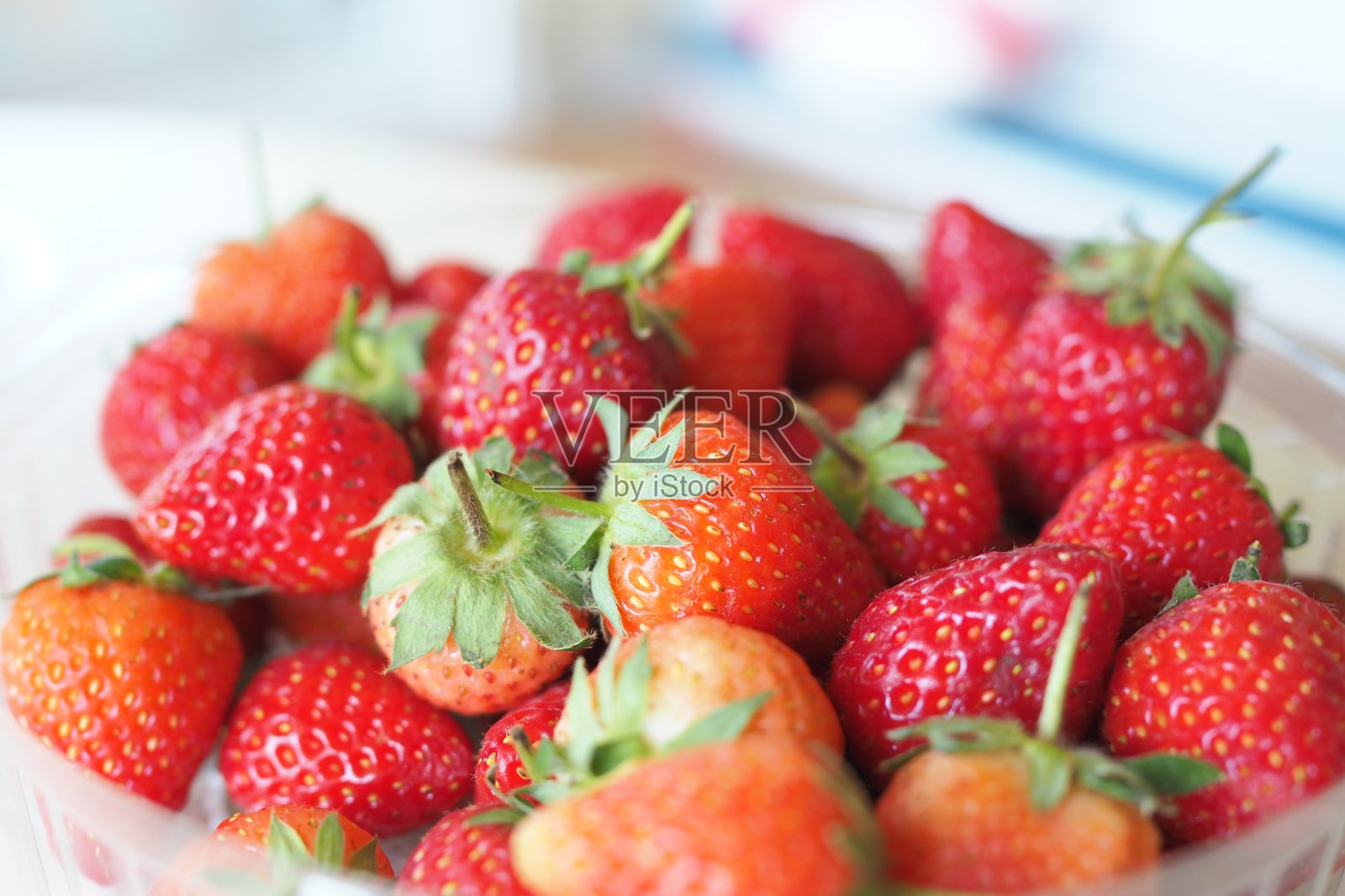 把新鲜草莓堆在一个白色的碗里照片摄影图片