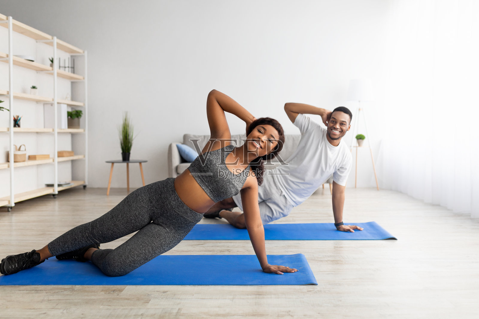 幸福的黑人夫妇站在一边的瑜伽垫在家里，复制空间照片摄影图片