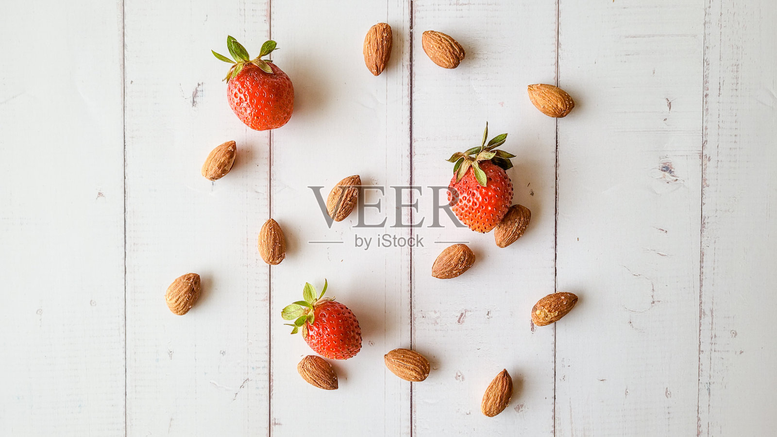 食物背景与草莓和杏仁在白色木制餐桌。照片摄影图片