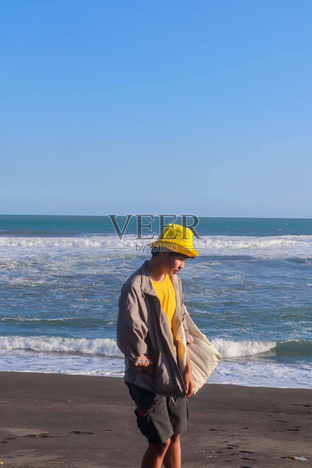 一个印度尼西亚少年在海滩上散步照片摄影图片