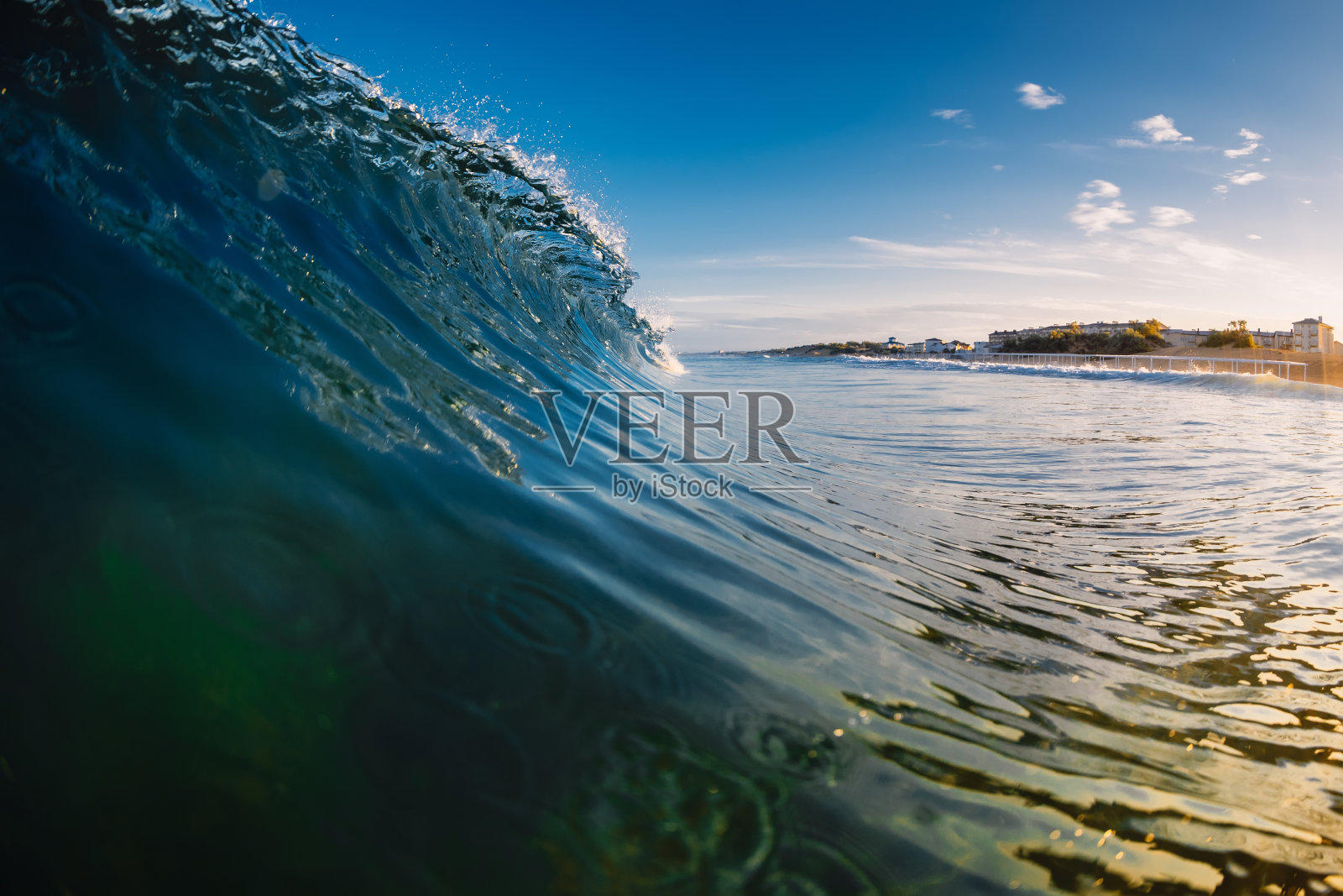 在日出或日落时，以温暖的音调在海洋中冲浪照片摄影图片