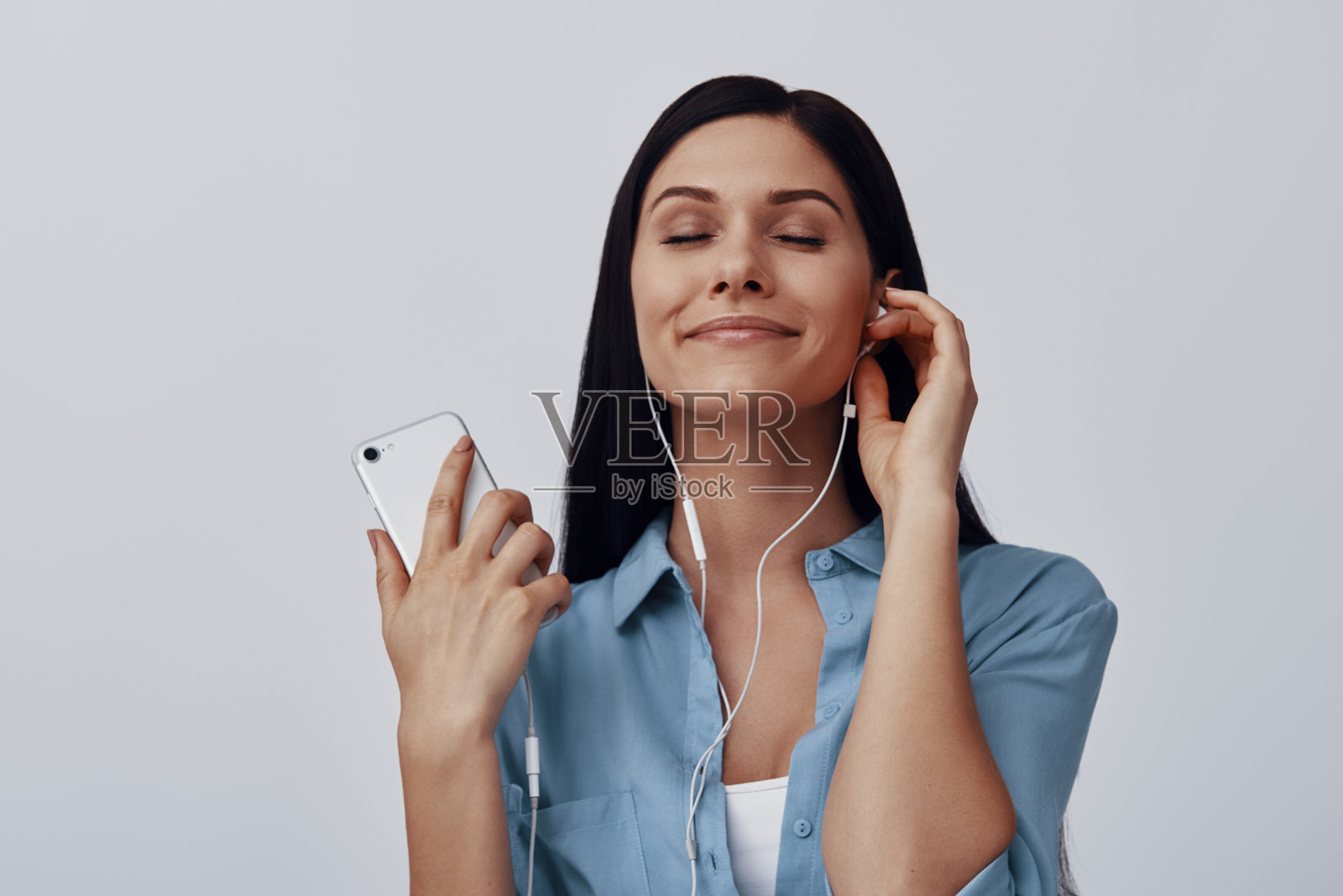 迷人的年轻女子听着音乐，面带微笑照片摄影图片