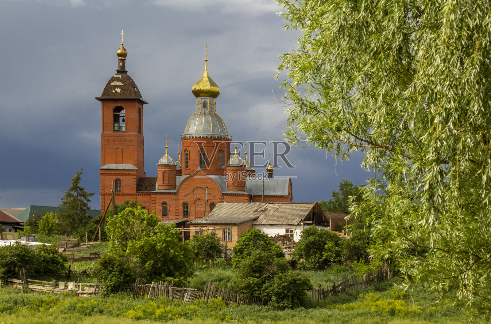 雨前森林附近的一个古老的乡村教堂。照片摄影图片