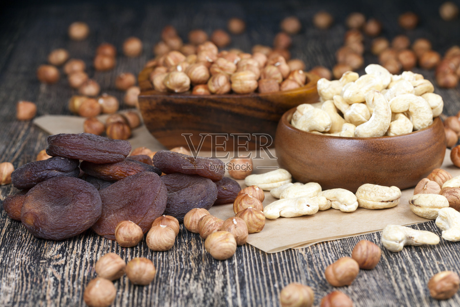 在旧木桌上放着腰果、榛子和其他干果照片摄影图片
