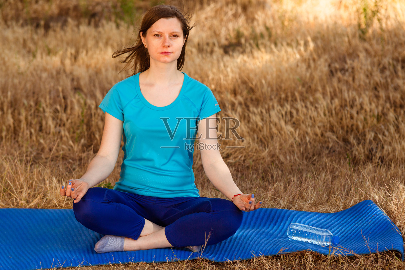 年轻女子在森林中冥想，放松瑜伽摆出健康的生活方式。照片摄影图片