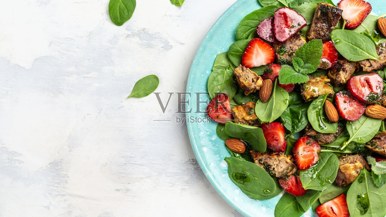 草莓菠菜沙拉配鸡肝，杏仁和薄荷。生酮饮食晚餐，生酮饮食午餐。饮食菜单，横幅，食谱地方的文字，俯视图照片摄影图片