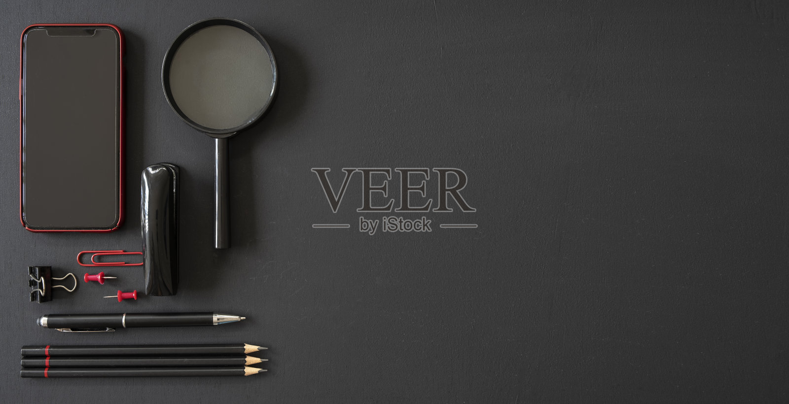 办公室黑色工作区与办公用品和拷贝空间在黑色背景，平铺照片摄影图片